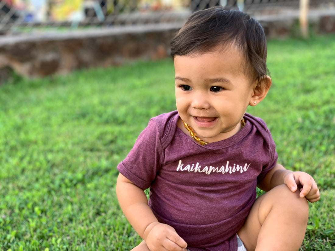 baby girl wearing the keiki dept shirt that says kaikamahine