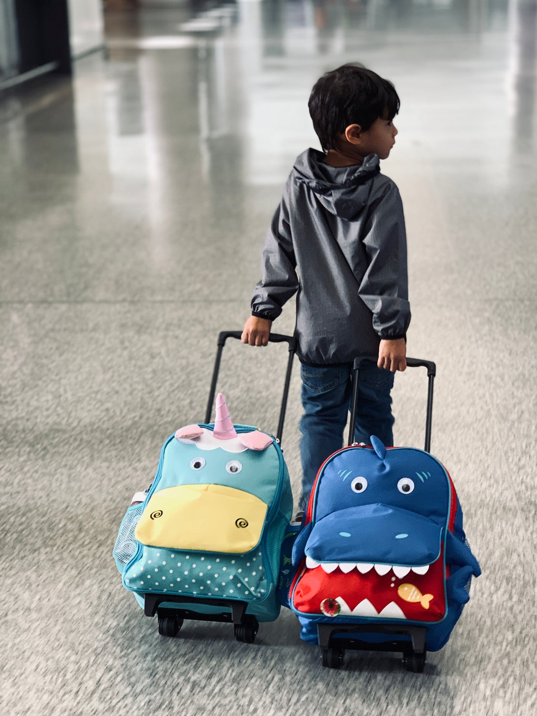 toddler wheel two toddler suitcases at the airport