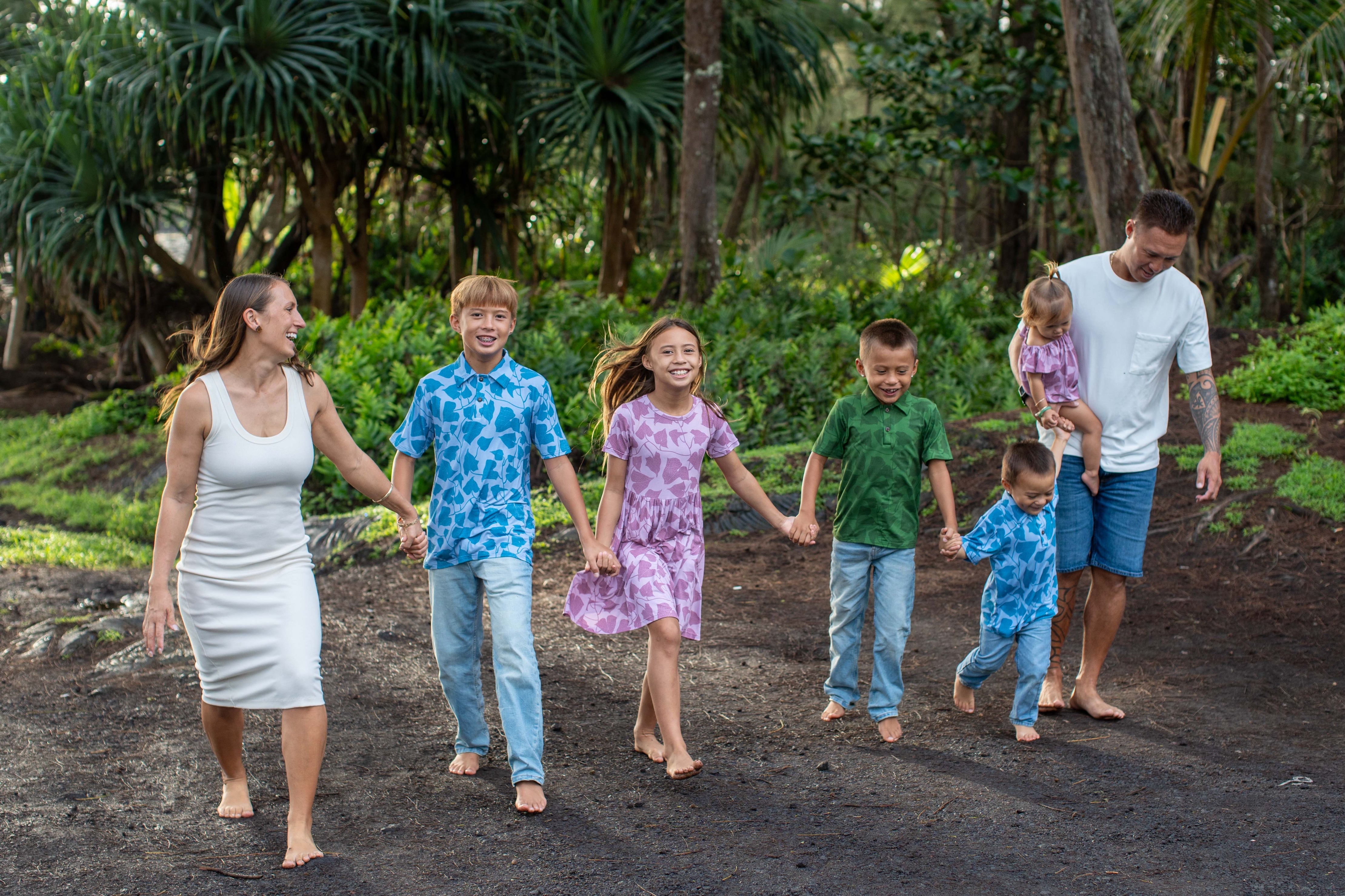 family wearing peʻahi fern prints. girls are in pink, boys are in blue and green colorways.