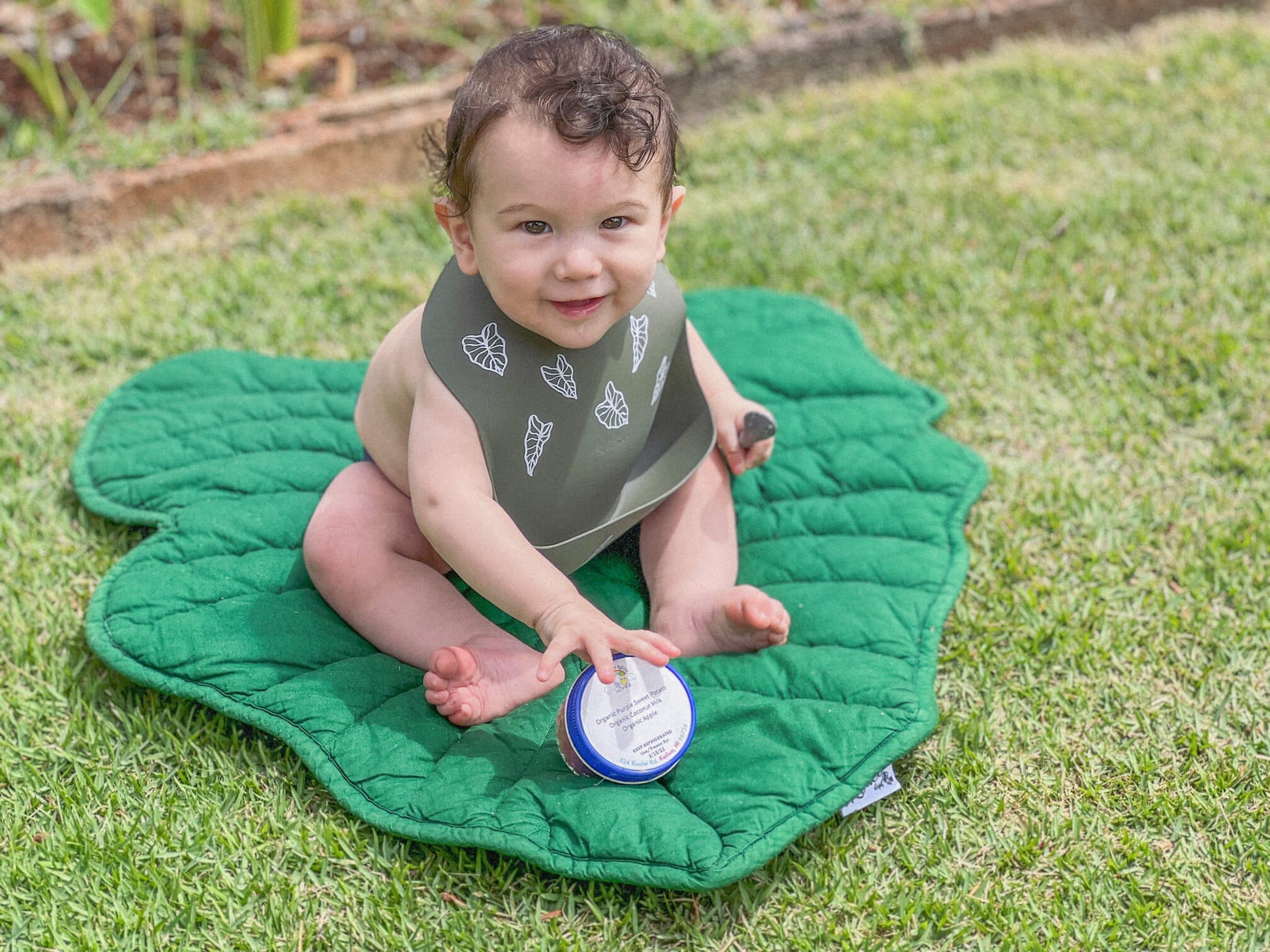 baby sitting on kalo paani mat wearing kalo silicone bib from the keiki dept