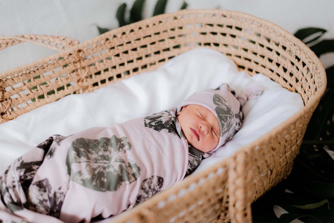 newborn baby swaddled in the kalo stamp jersey blanket and knot beanie from the keiki dept