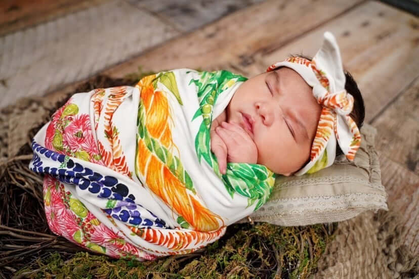 professional photoshoot with everly. she is wearing the knot bow and swaddle with the jersey blanket from the lei anuenue aloha baby set from the keiki dept