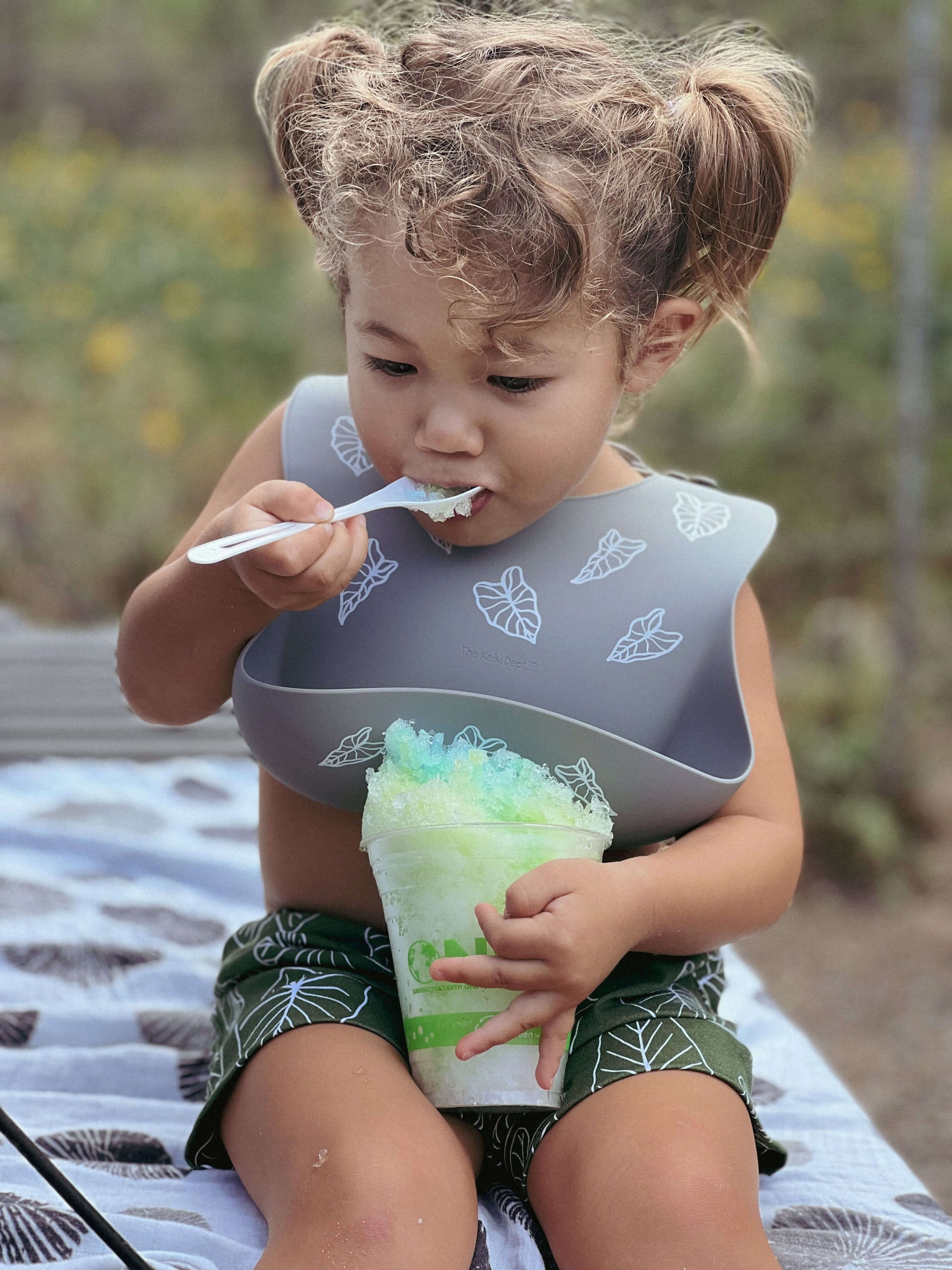toddler eating shave ice wearing kalo silicone bib