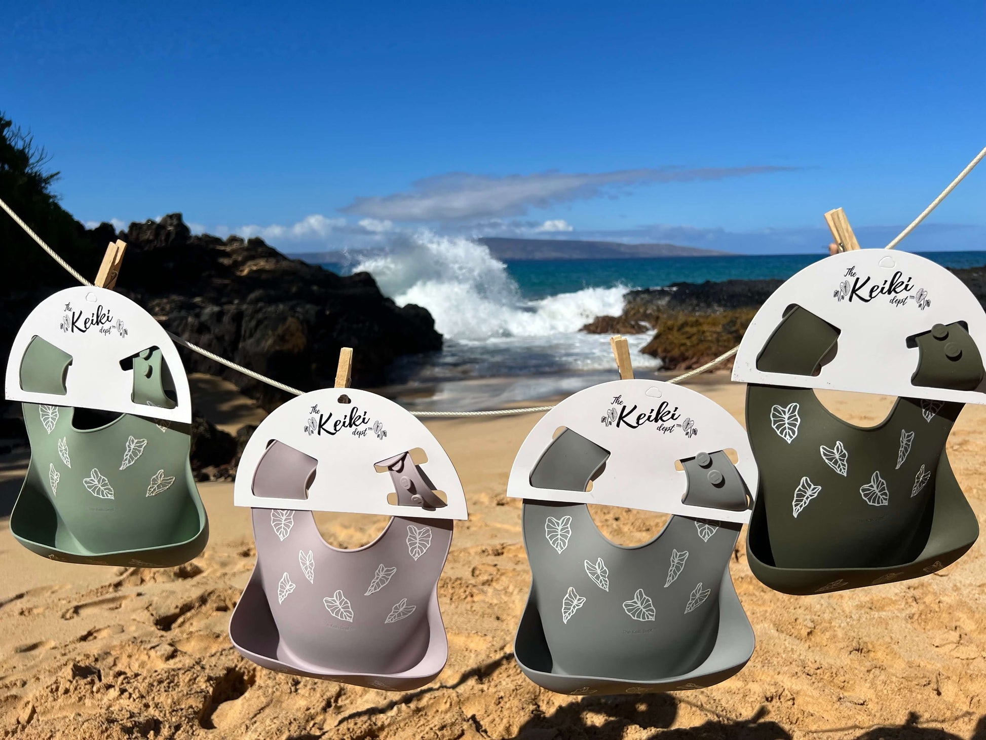 kalo silicone bibs from the keiki dept hanging on a clothesline at the beach