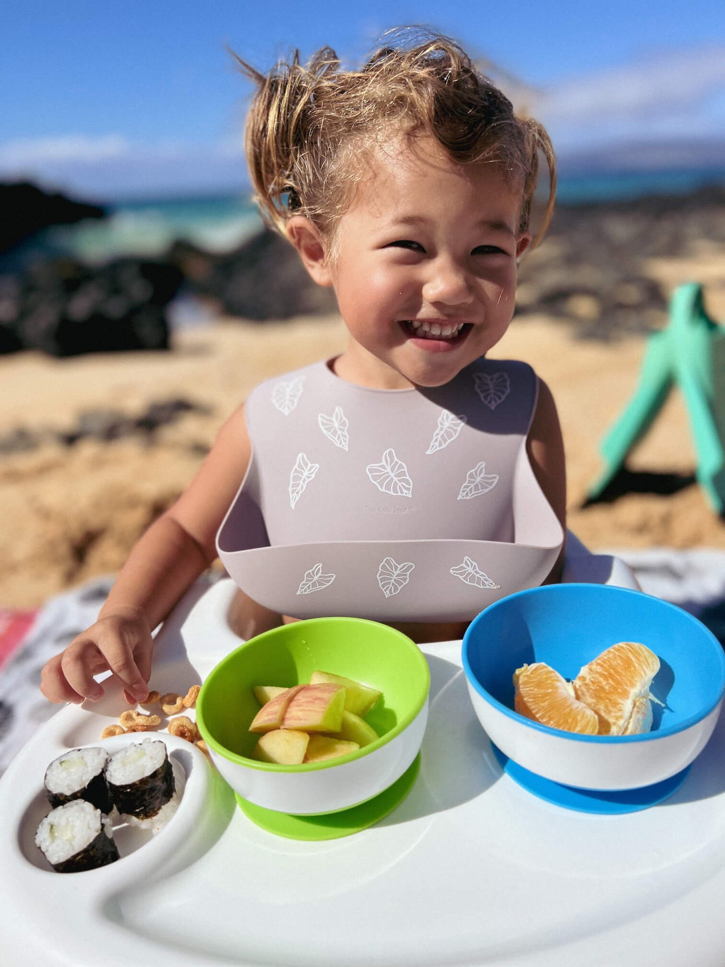 toddler wearing poi kalo silicone bib at teh beach